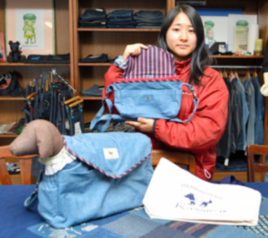 散歩用の道具を持ち運べるミニバッグを持つ坂本麗名さん。手前が「お散歩バッグ」＝福山市神辺町